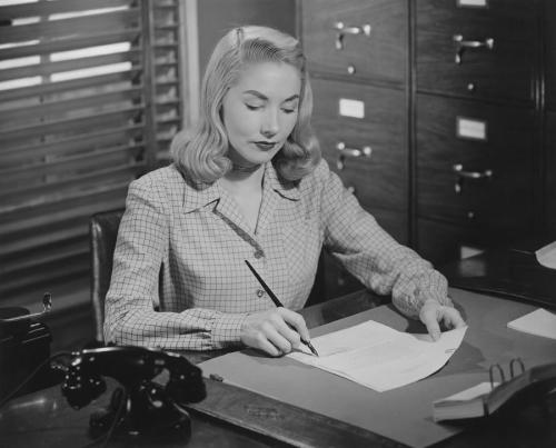 woman-sitting-at-desk-writing-letter-bw-george-marks